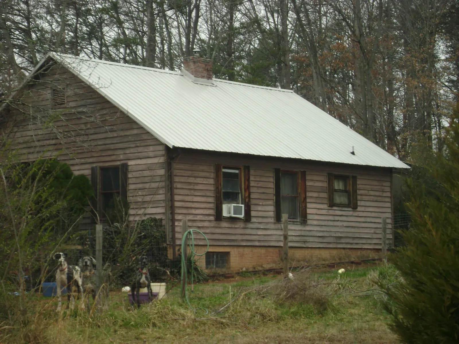 White metal roof on an old wood sided farmhouse, from a Metal Roof Installation job in Honey Grove